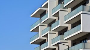 Modern building with glass balconies against sky.